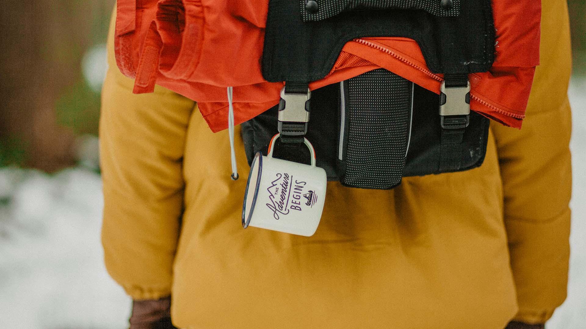 A hiker with backpack and coffee cup. A hiker with backpack and coffee cup.
