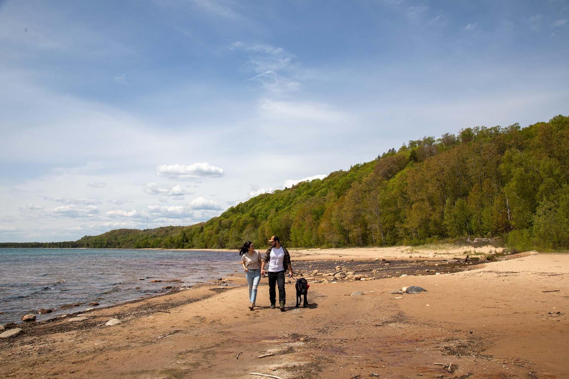 A couple walking along the beach near the Cut River Bridge.